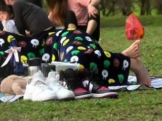 Voyeur filming a hot amateur babe with sexy feet in the park