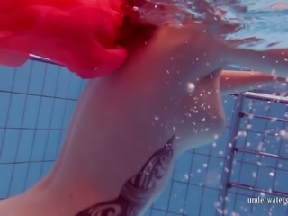 Fire red haired girl Katrin Privsem swimming naked in a pool